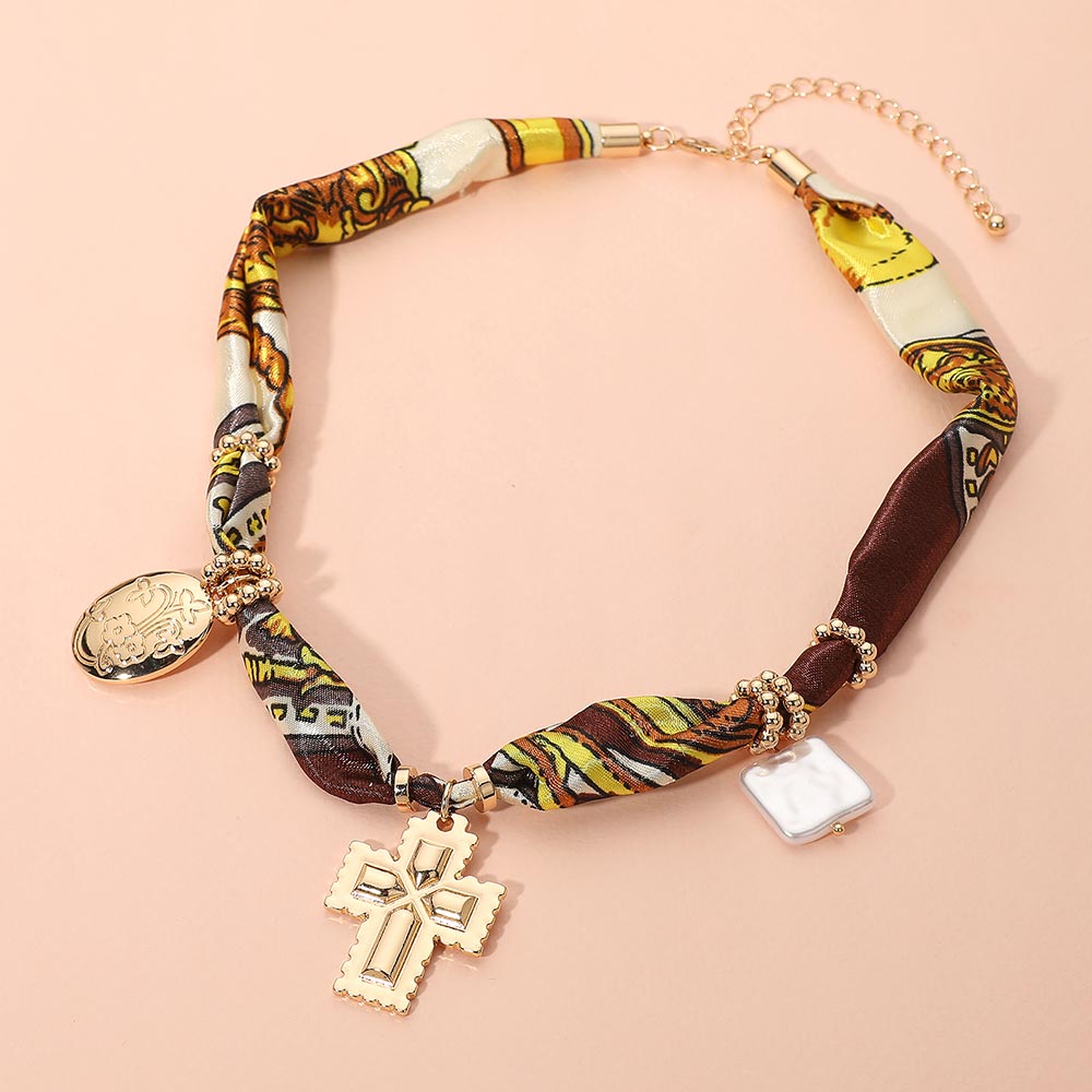 Collar boho de tela con dije de metal cruzado, perla cuadrada y floral ovalado