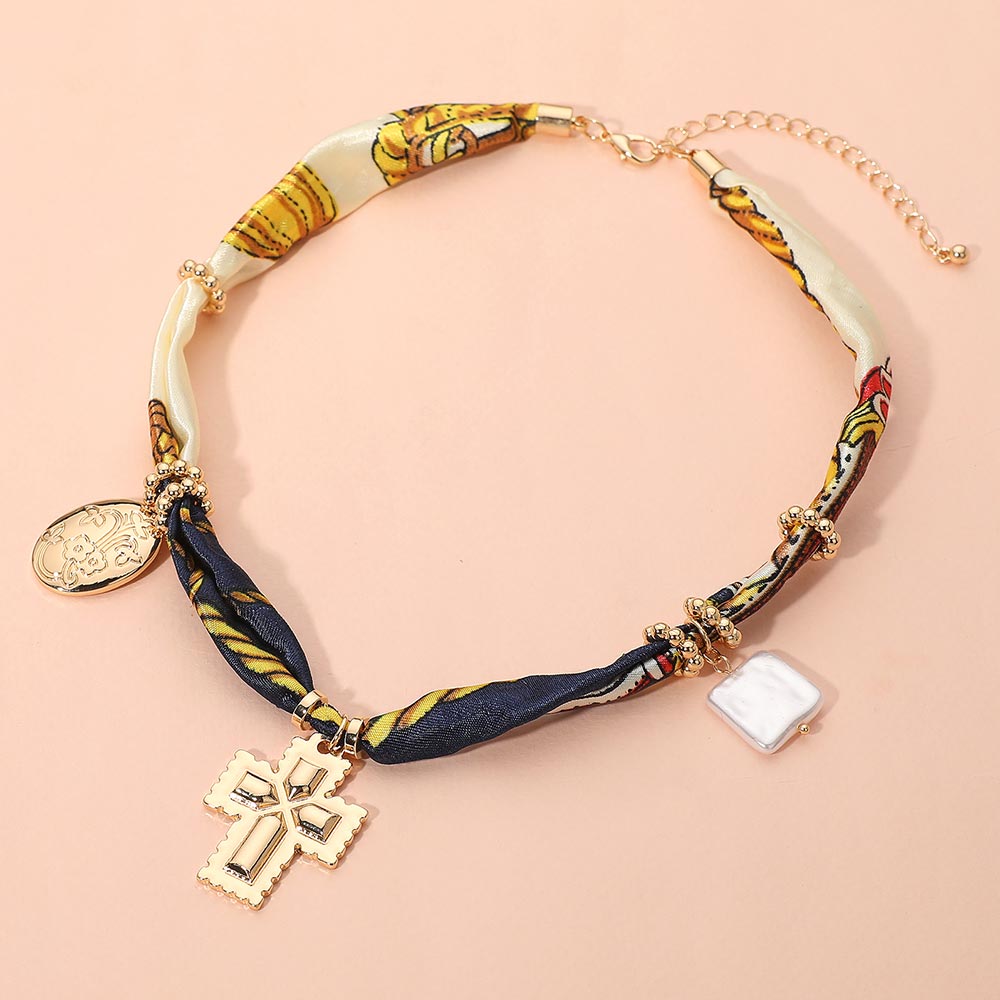 Collar boho de tela con dije de metal cruzado, perla cuadrada y floral ovalado