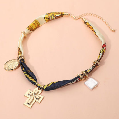Collar boho de tela con dije de metal cruzado, perla cuadrada y floral ovalado