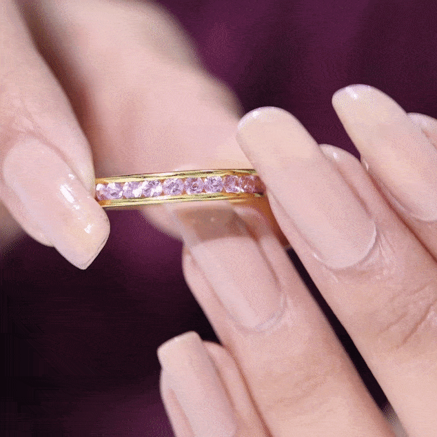 Anillo de media eternidad de zafiro rosa redondo creado en laboratorio con engaste de canal