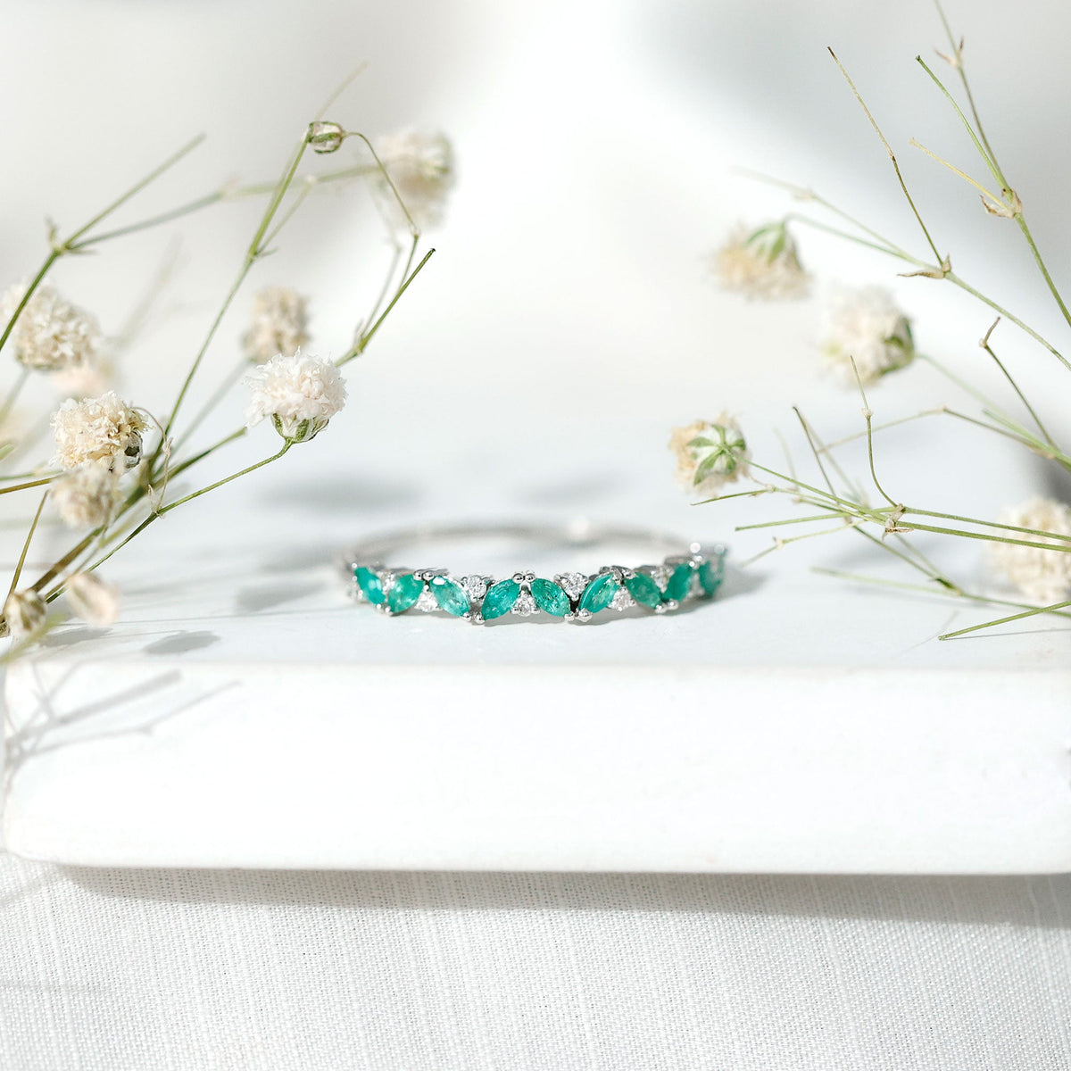 Anillo de media eternidad de esmeraldas y diamantes marquesa