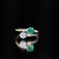 Anillo de compromiso de dos piedras de esmeralda y moissanita con vástago cruzado