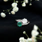 Anillo de compromiso de dos piedras de esmeralda y moissanita con vástago cruzado