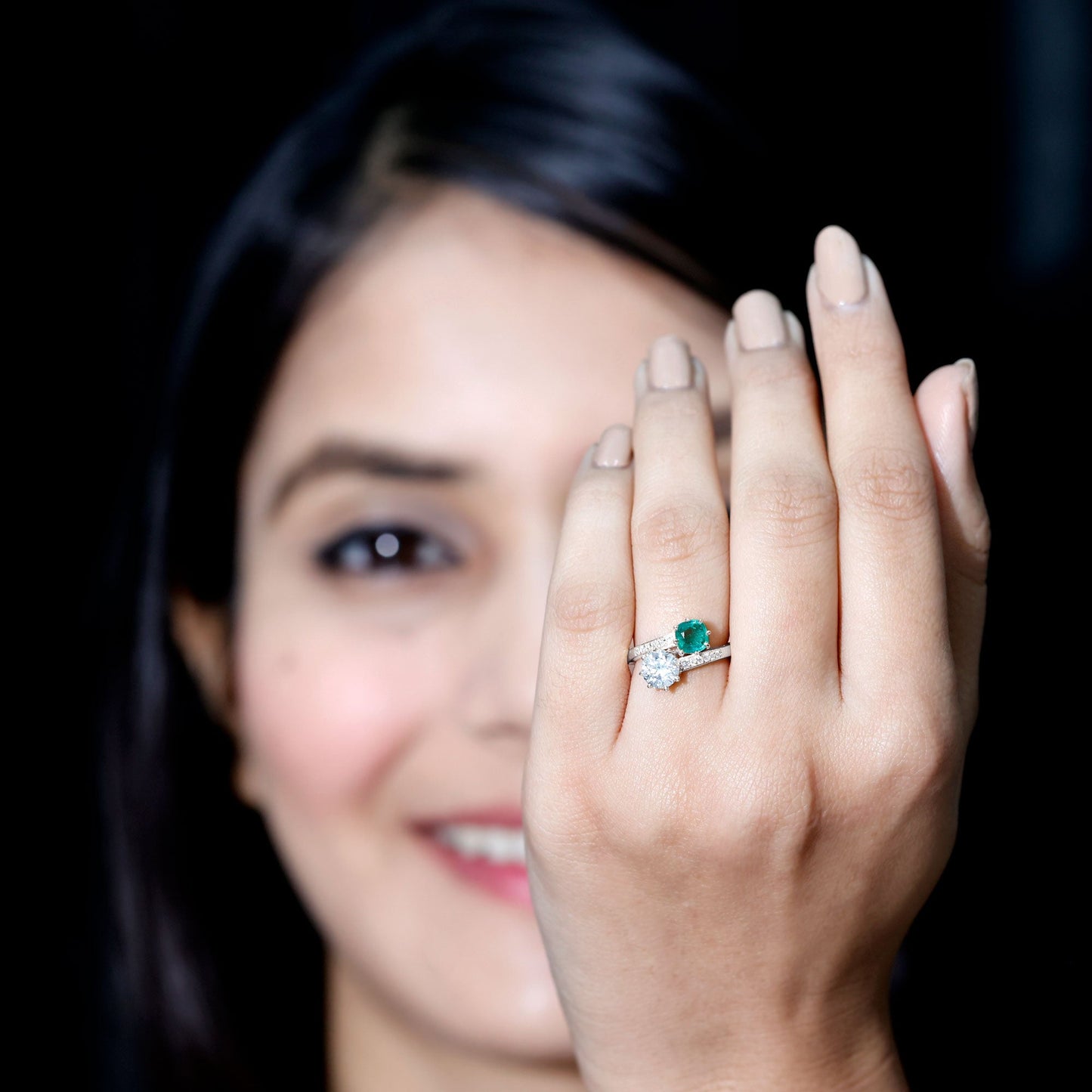 Anillo de compromiso de dos piedras de esmeralda y moissanita con vástago cruzado