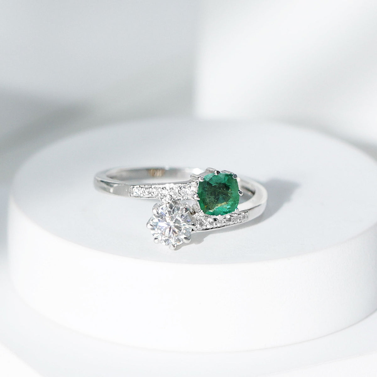 Anillo de compromiso de dos piedras de esmeralda y moissanita con vástago cruzado