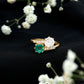 Anillo de compromiso de dos piedras de esmeralda y moissanita con vástago cruzado