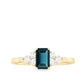 Anillo de compromiso de topacio azul de Londres talla esmeralda con trío de diamantes