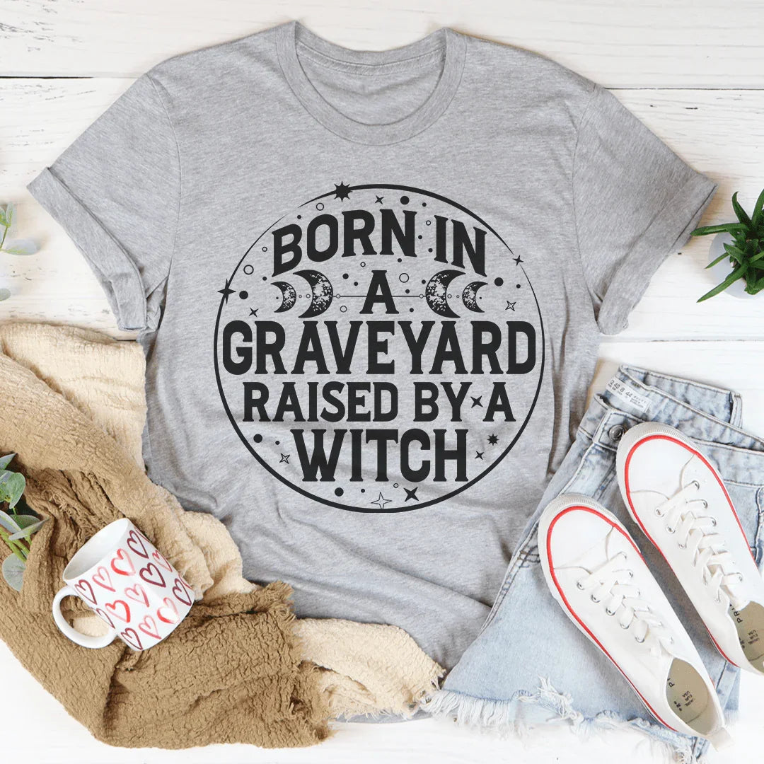 Witchy Dark Humor Top – "Born In A Graveyard Raised By A Witch" Graphic T-Shirt