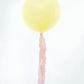 Cola de borlas de papel en colores pastel rosa y amarillo
