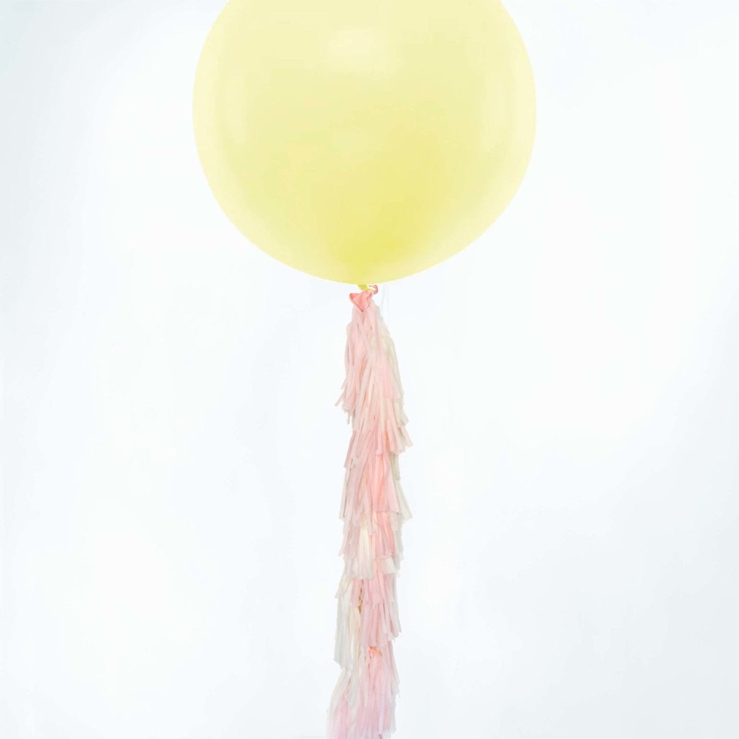 Cola de borlas de papel en colores pastel rosa y amarillo